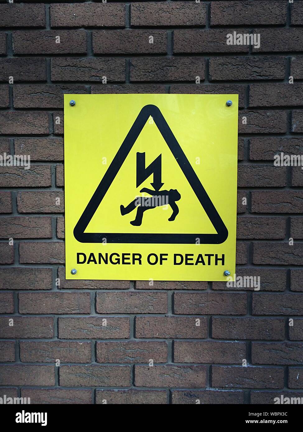 Danger Of Death Sign Board On Brick Wall Stock Photo