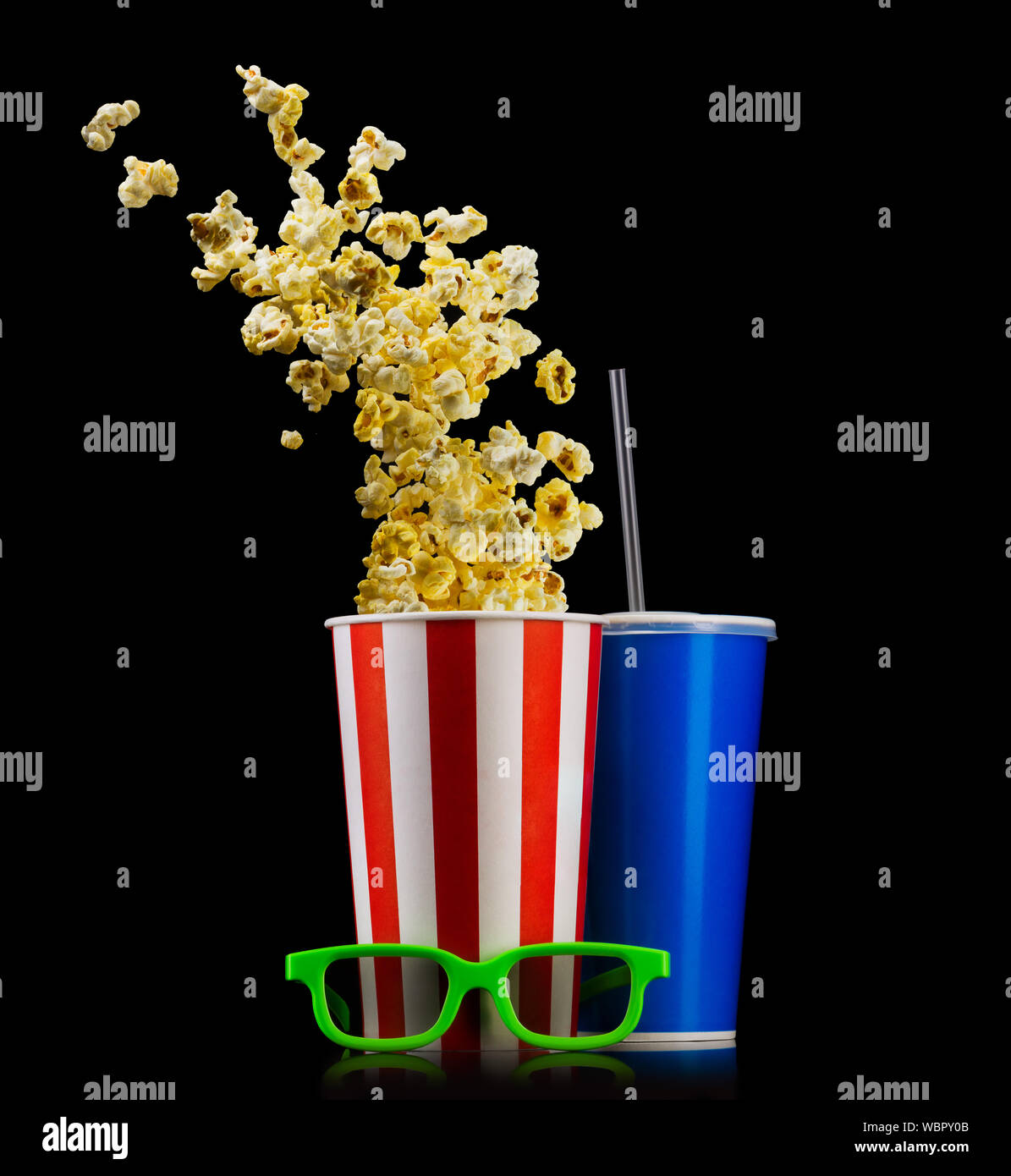 Paper striped bucket with popcorn, cup of drink and glasses isolated on black Stock Photo