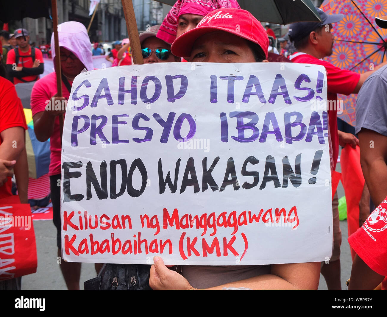 A woman holds a placard which says, salaries to be increase, during the demonstration.Thousands of workers took to the streets as the Philippines marked National Heroes' Day. They call it the 'Martsa ng Manggagawa Laban sa Kontraktwalisasyon' (Workers' March Against Contractualization). They slammed the Duterte Government for allegedly turning a blind eye to the abuses suffered by workers. The United workers calling for an end to 'ENDO' or end of contractualization of workers and the increase of minimum wage of workers to 750 pesos. Stock Photo