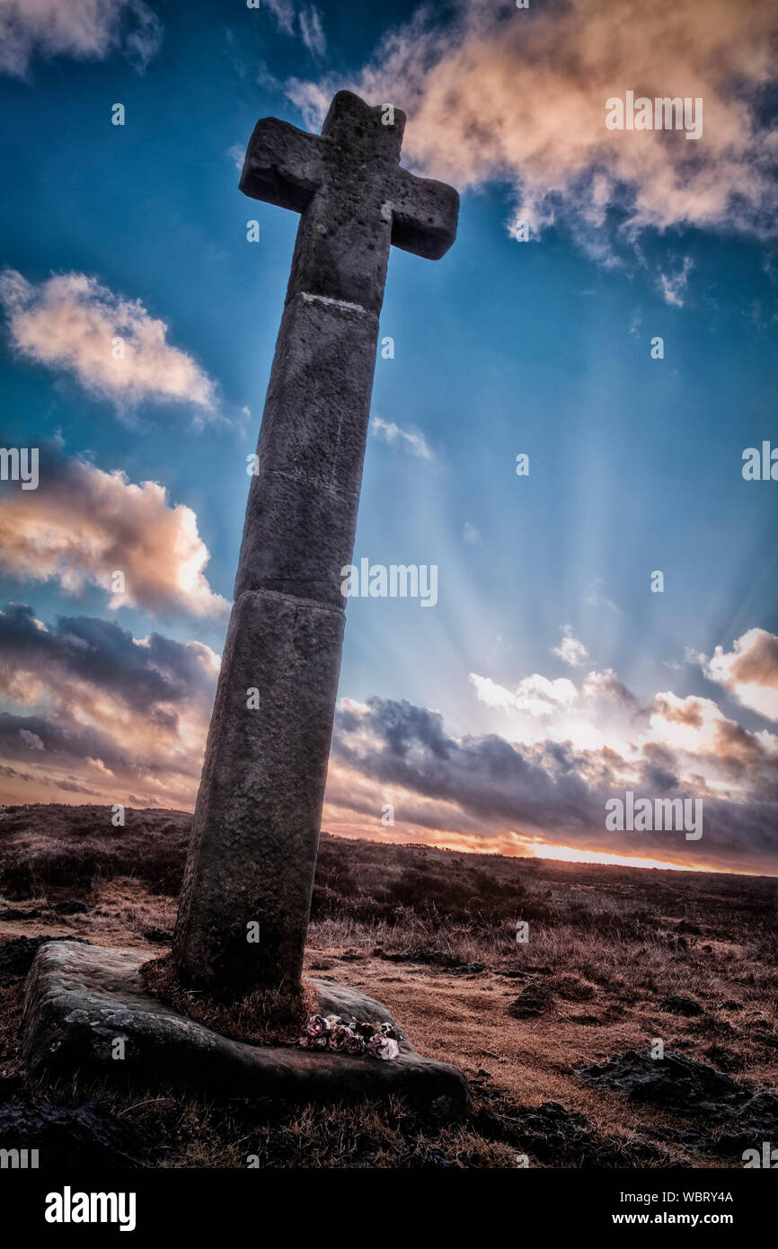 stylised shot of stone cross in isolated moorland location at sunset Stock Photo