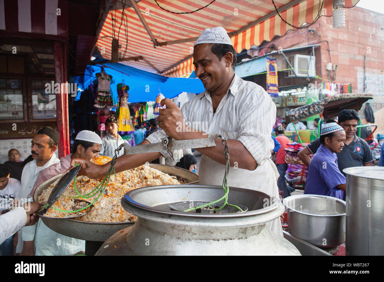 Muslim Cooks India, Delhi, A muslim cook serves a portion of rice biryani in the old ...