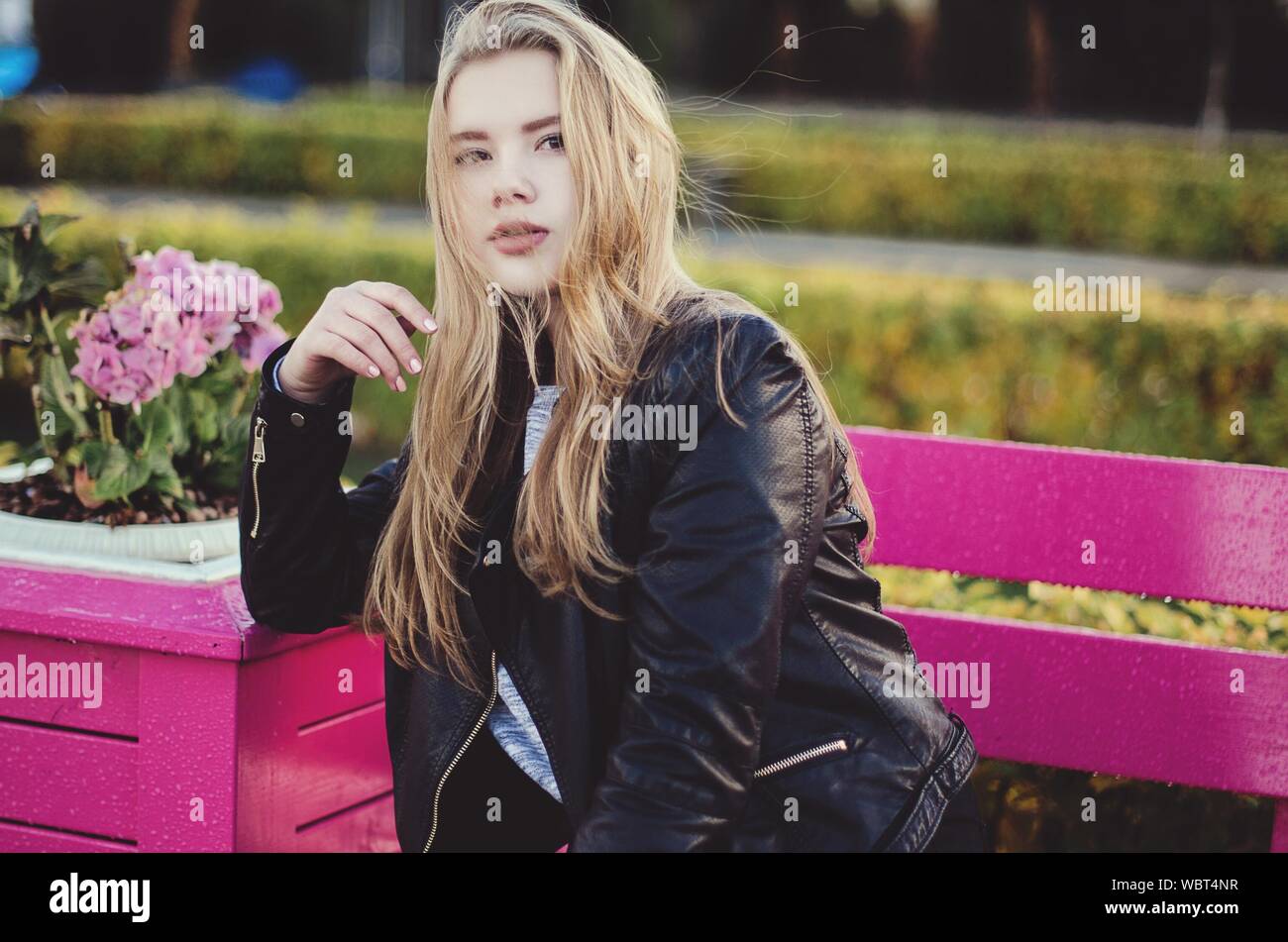 Portrait Of Woman On Pink Bench Stock Photo