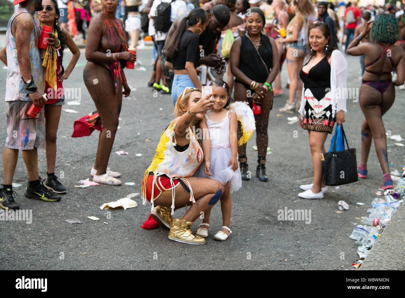 Two en standing text to each other wearing colourful shirts smiling at Notting Hill Carnival. Stock Photo