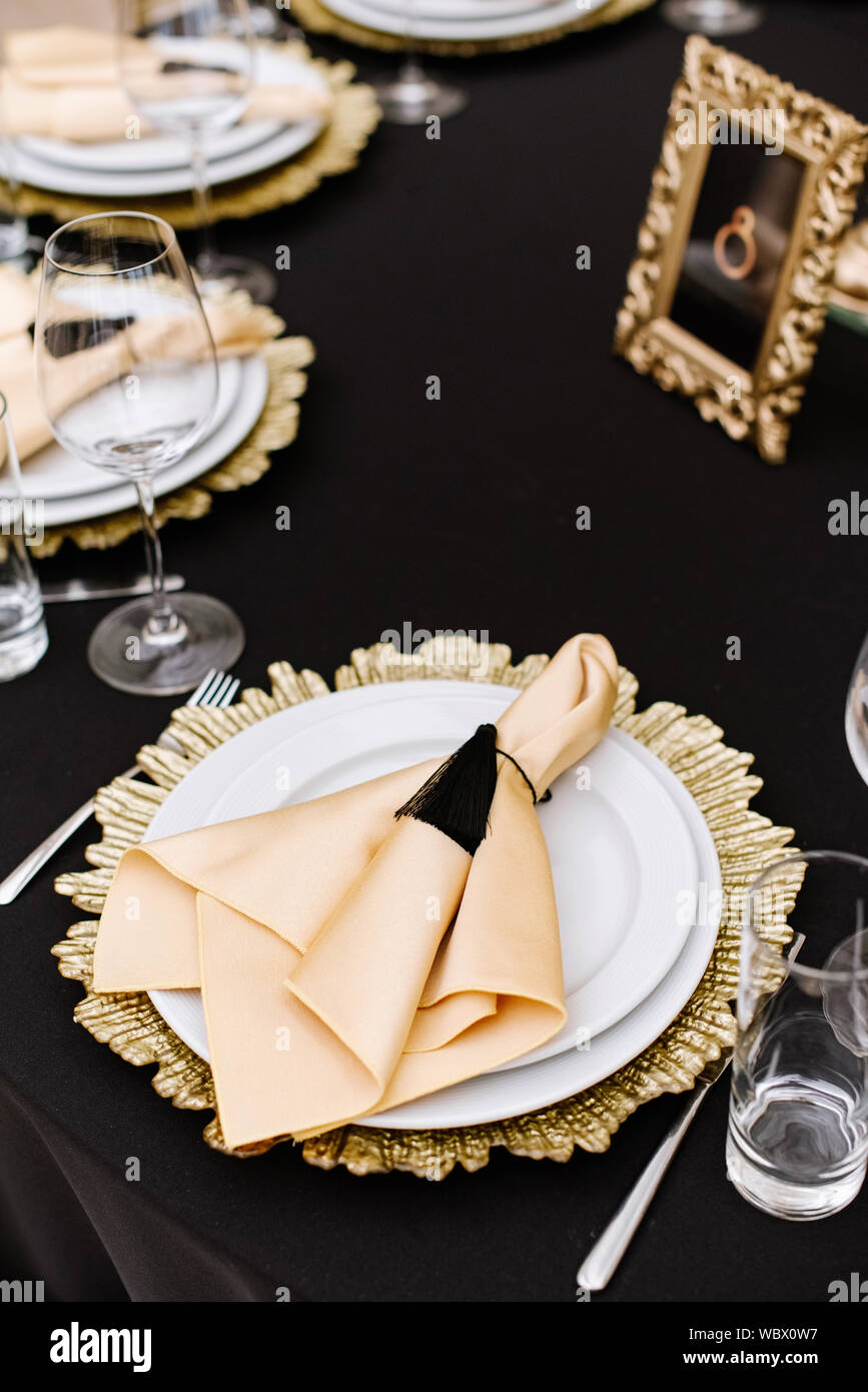 Fabric napkin for the guest at the holiday dinner. Beautiful service of wedding  tables. Black tablecloth on the table Stock Photo - Alamy, image size:867x1390