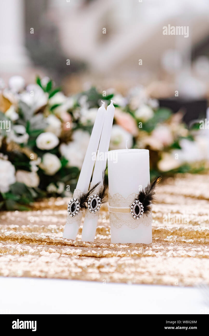 White wedding candles for the ceremony, decorated with an elegant pin