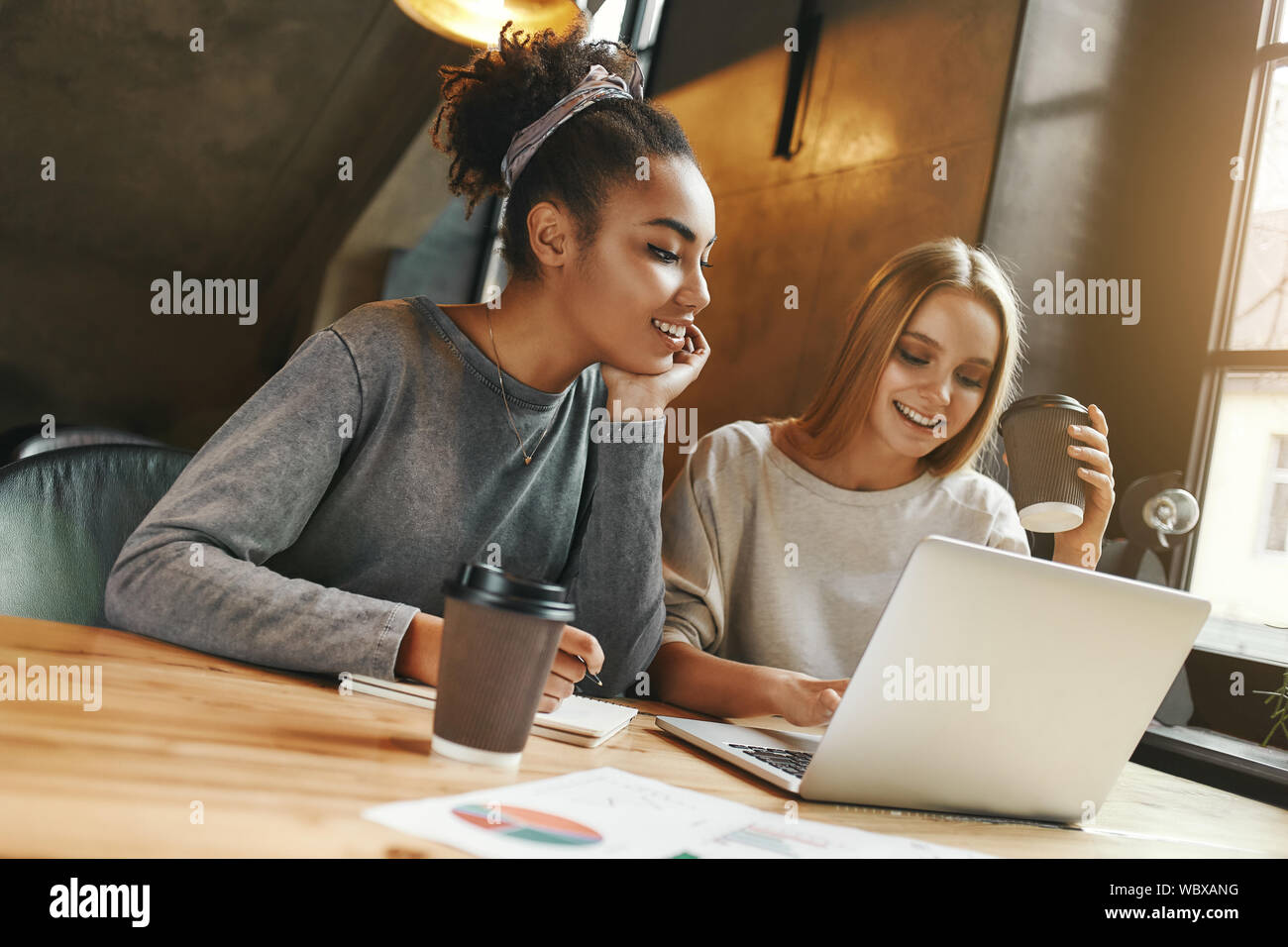 Portrait of two multiracial young female friends surfing the internet ...