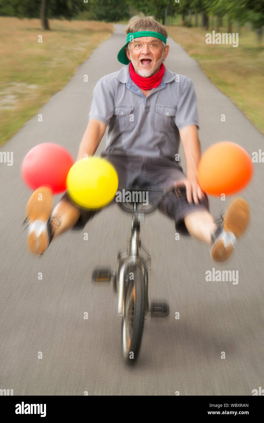 Man with balloons and children's bike Stock Photo