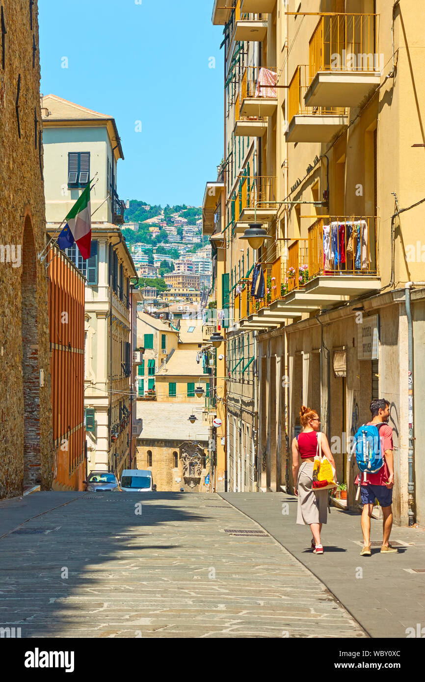 Genoa, Italy - July 4, 2019:  Old street in Genoa with walking people on sunny summer day Stock Photo