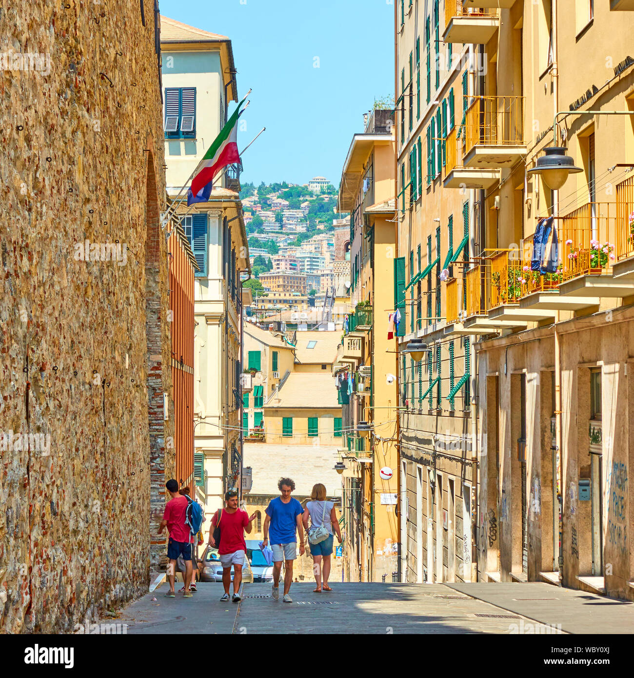 Genoa, Italy - July 4, 2019:  Old street in Genoa with walking people on sunny summer day Stock Photo