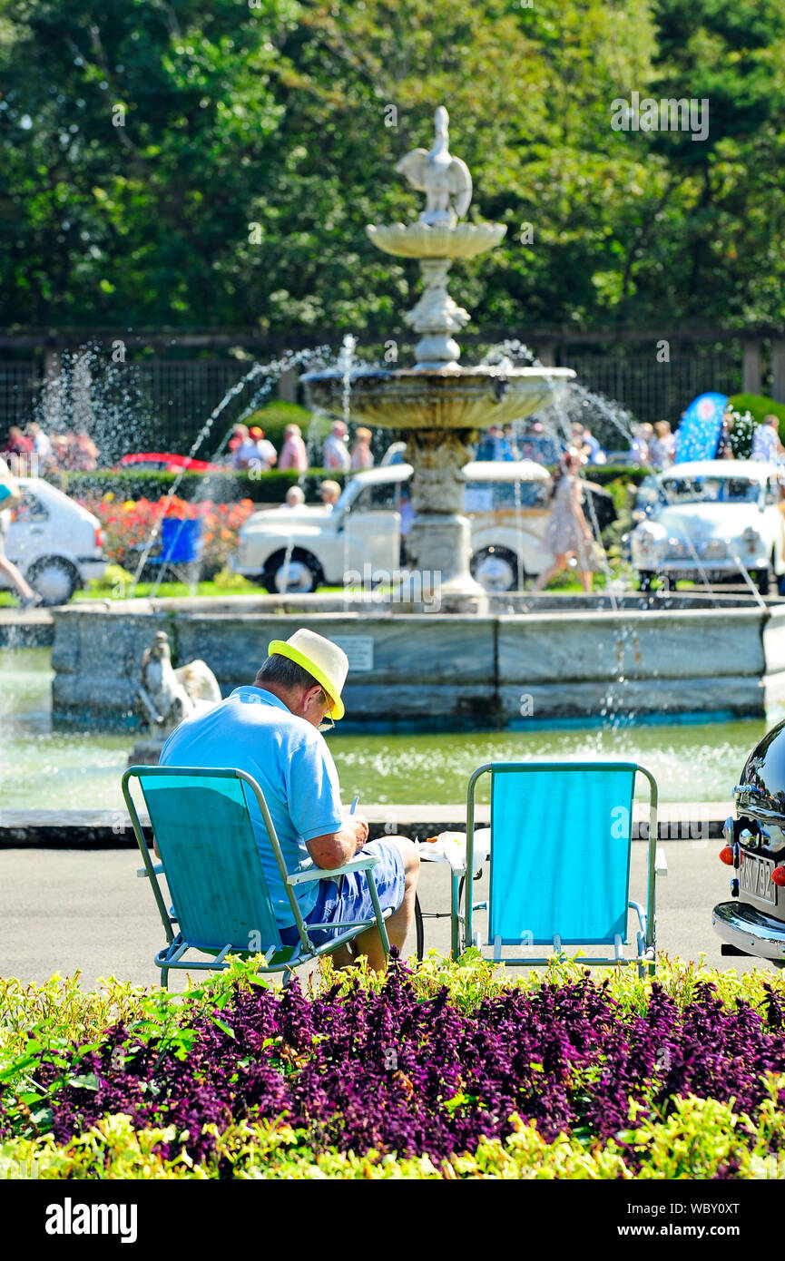 Blackpool Vehicle Preservation Group show at Stanley Park,Blackpool. Man sat in folding chair relaxing in front of an ornamental fountain Stock Photo
