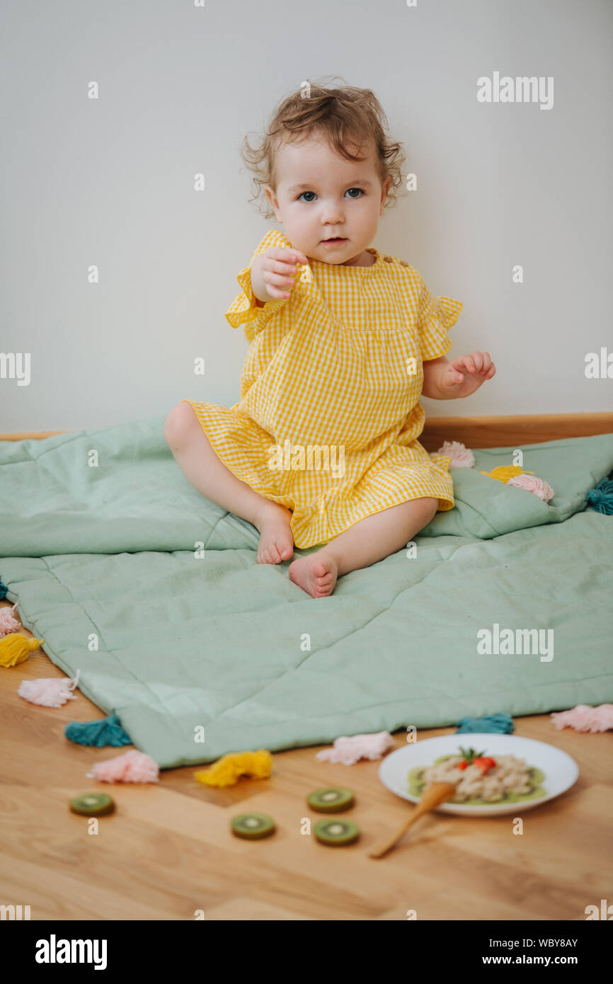 Cute babe sitting in the game zone is ready to eat oatmeal Stock Photo -  Alamy