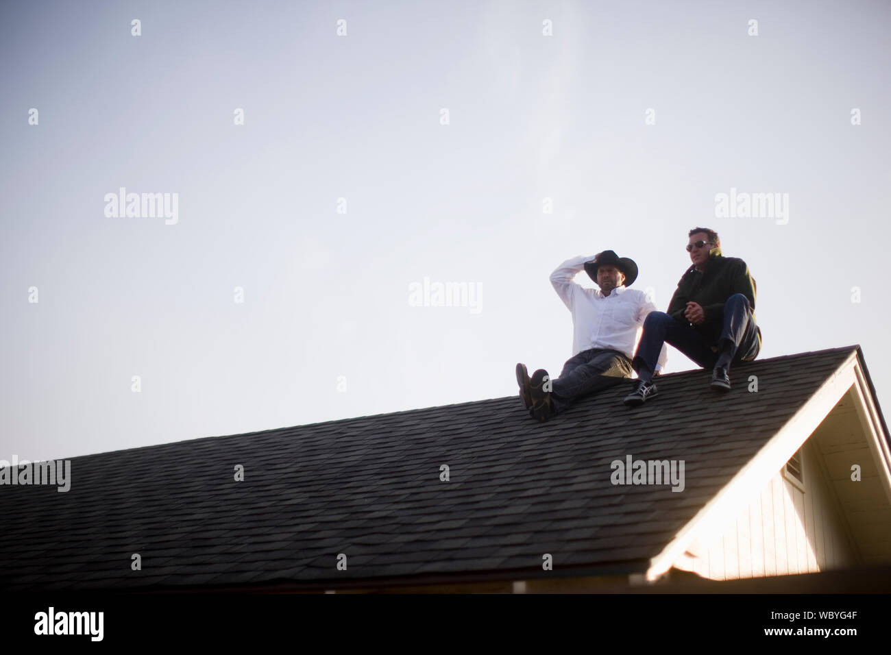 Two people sit on roof hires stock photography and images Alamy