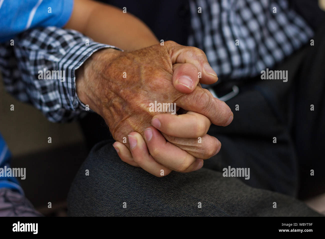Cropped Grandfather Holding Hand Of Grandchild Stock Photo