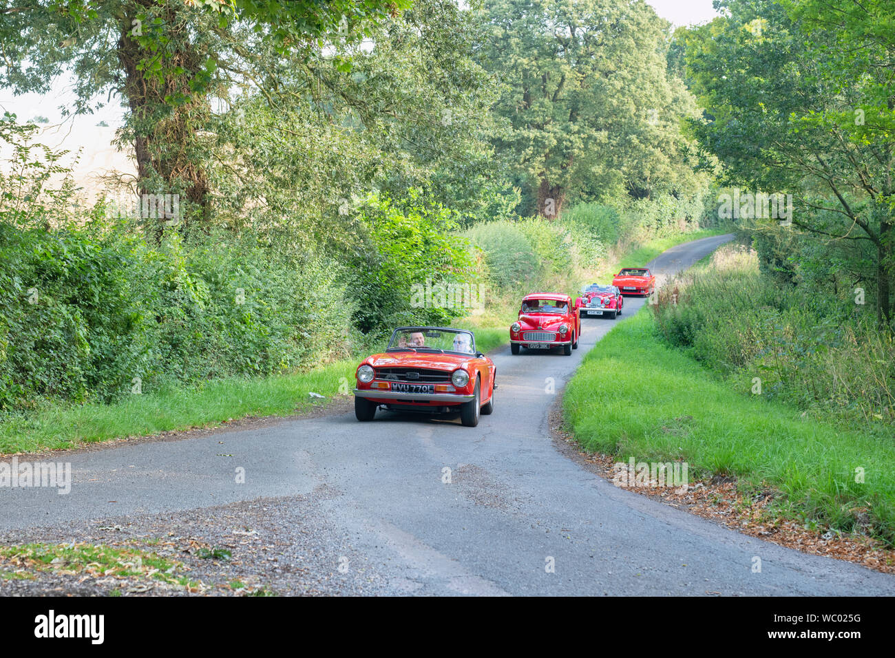 Red classic cars on there way to a classic car show in the Oxfordshire