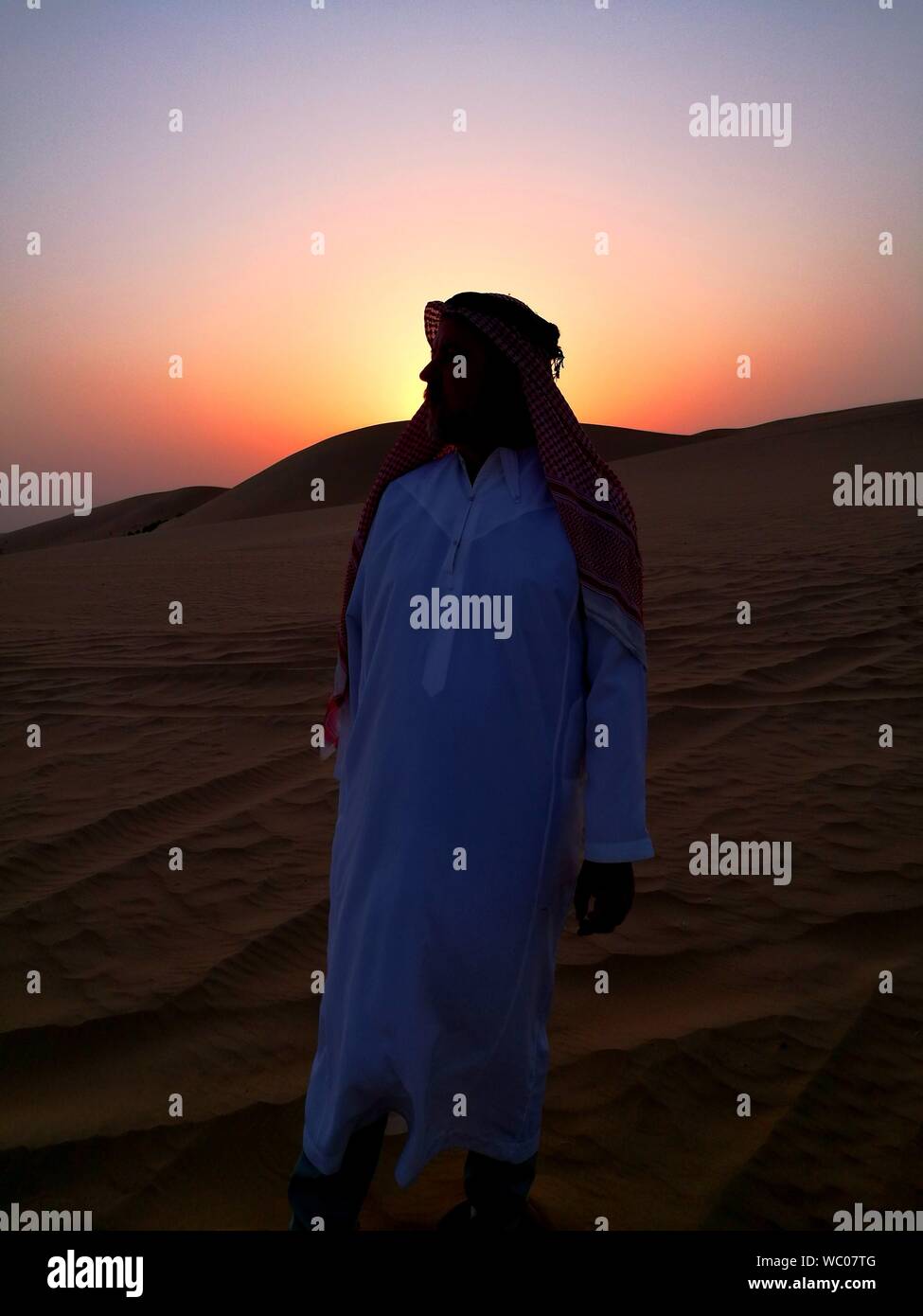 Full Length Of Arab Man Standing In Desert Stock Photo