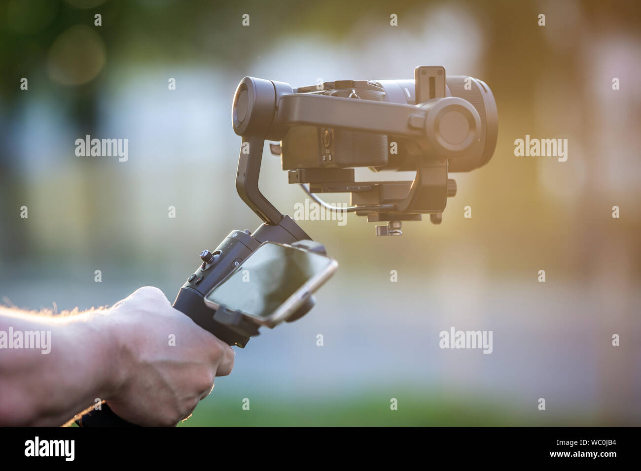 Man operating a gimbal stabilizer outdoor. Stock Photo