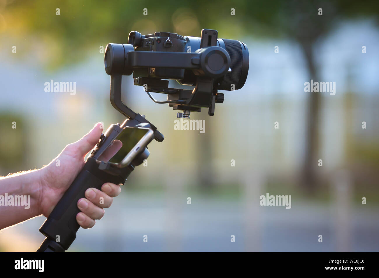 Man operating a gimbal stabilizer outdoor. Stock Photo