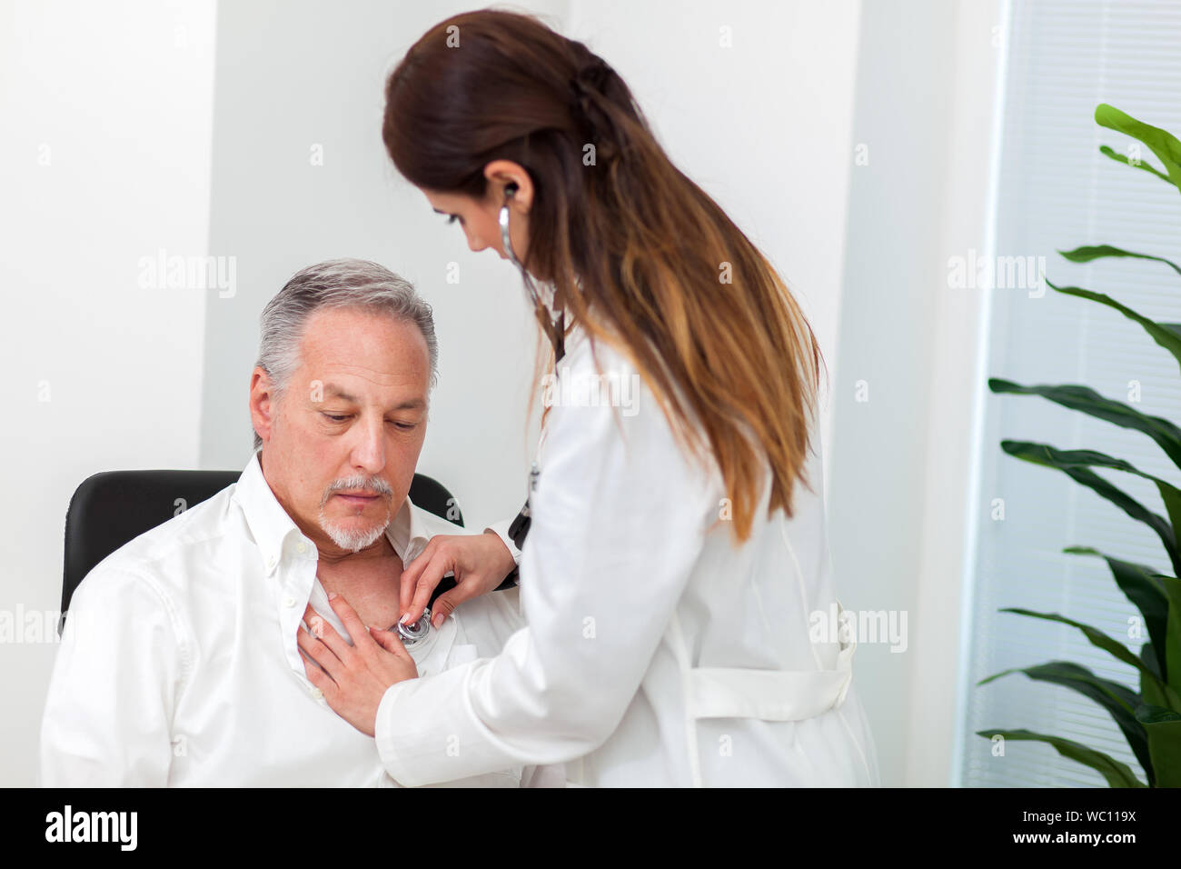 Female doctor checking a patient's heartbeat Stock Photo - Alamy