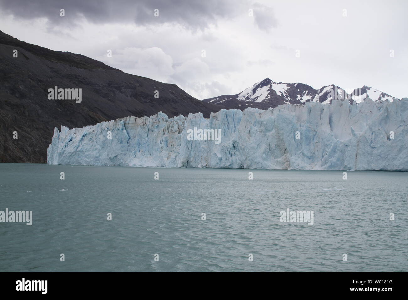 Ice Formation In River At Ohiggins Glacier Against Mountains Stock Photo