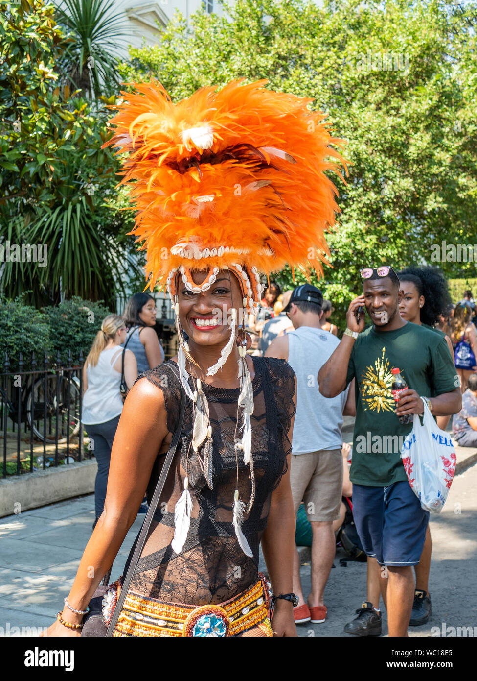 Lady with bright headdress smiling at the Notting Hill Carnival London. Stock Photo
