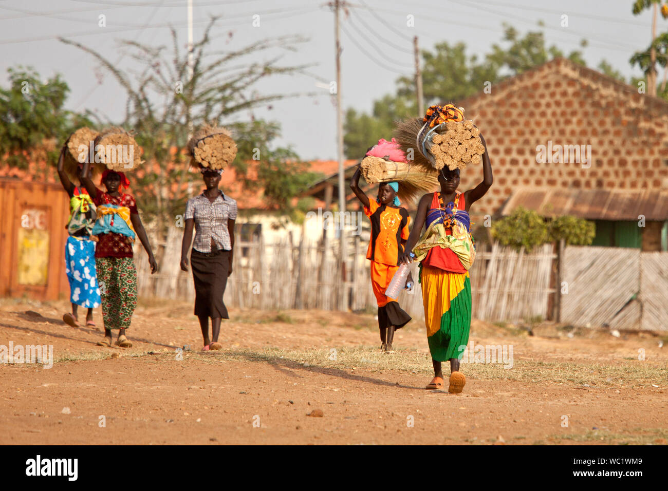 TORIT, SOUTH SUDAN-FEBRUARY 20, 2013: Unidentified women carry heavy loads on their heads in the village of Torit, South Sudan Stock Photo