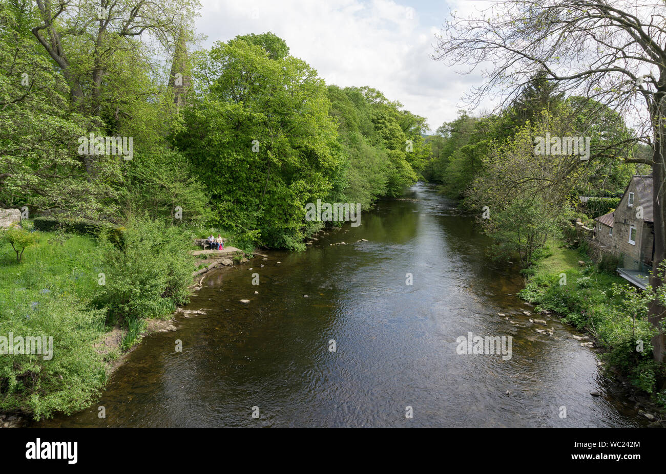Scenic Summer view of the River Derwent flowing through the village of Baslow, Derbyshire, UK