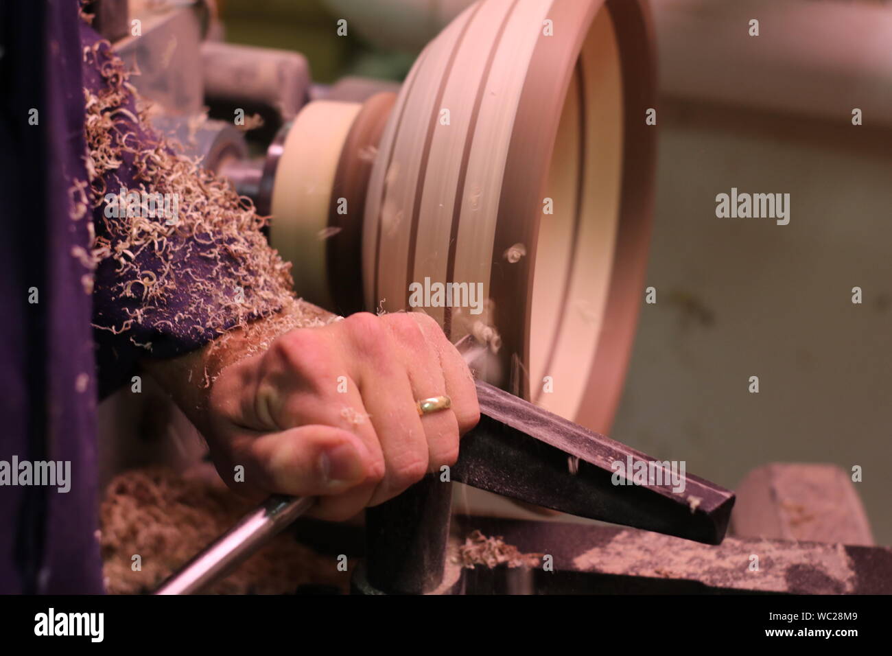 Woodworker at work, wood-turning a bowl on the lathe. Stock Photo