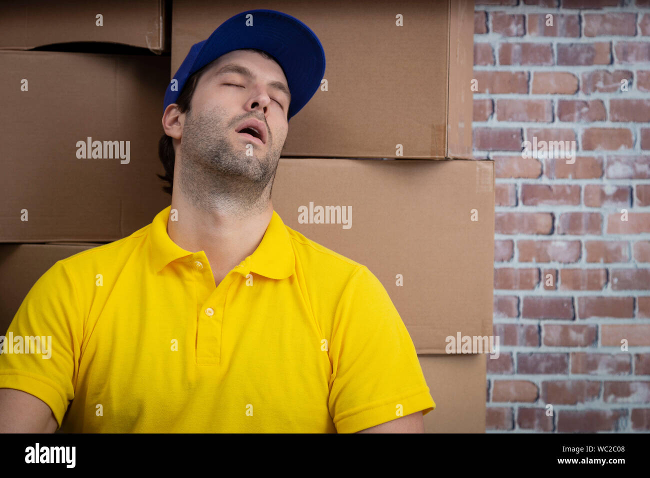 Brazilian mailman sleeping in a deposit with a a lot of boxes. Stock Photo