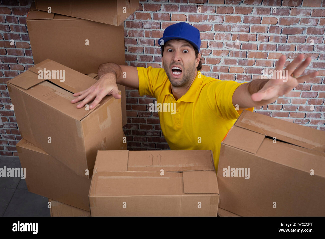 Brazilian mailman lost in a lot of boxes in a deposit Stock Photo