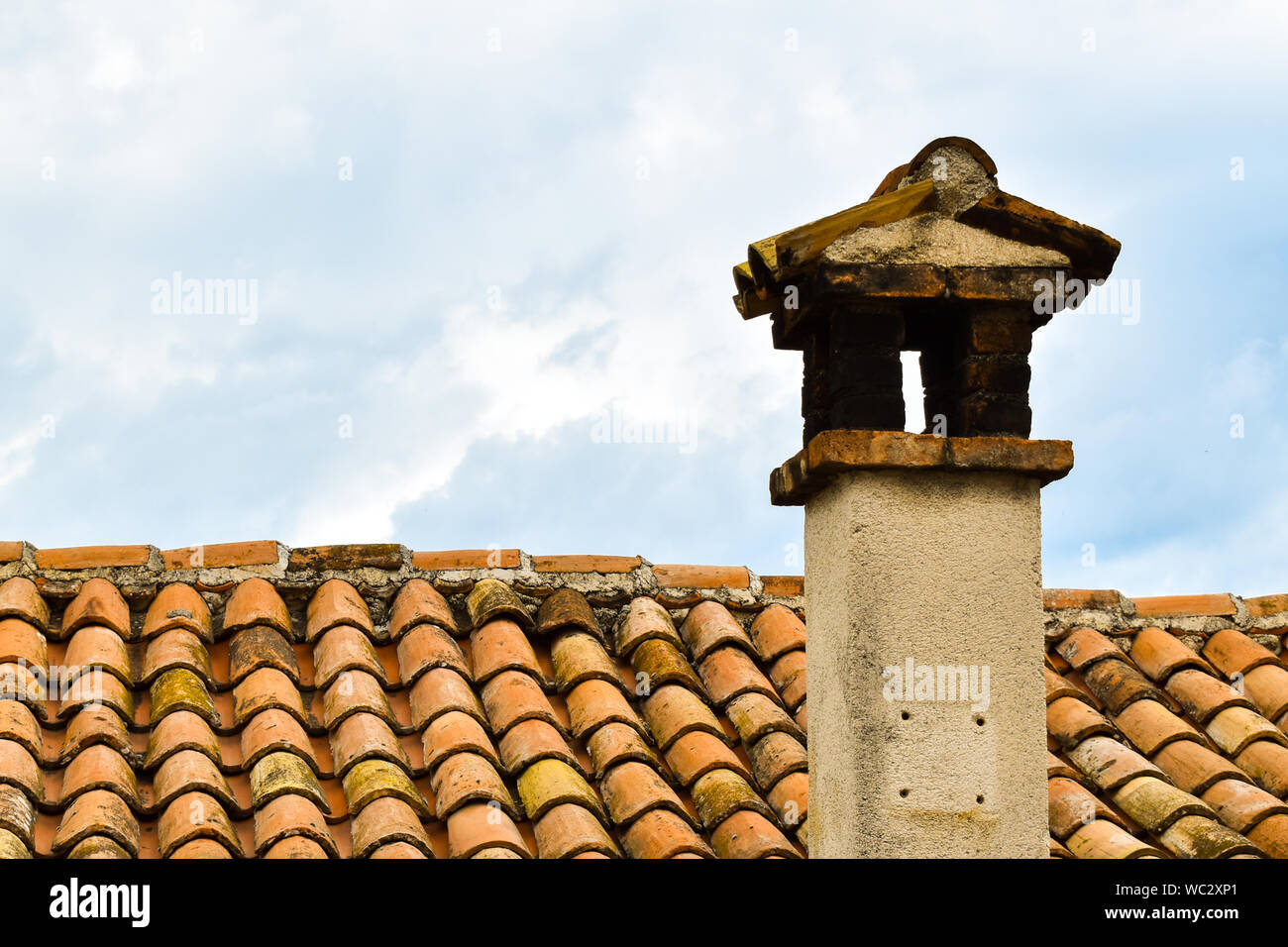 Close up shot of old orange roof with clay tiles and chimney. Roof of old house in Croatia Stock Photo