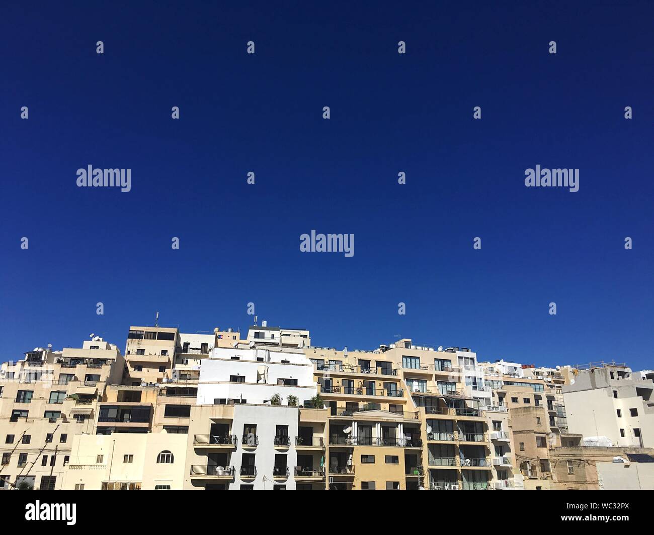 Buildings Against Clear Blue Sky Stock Photo