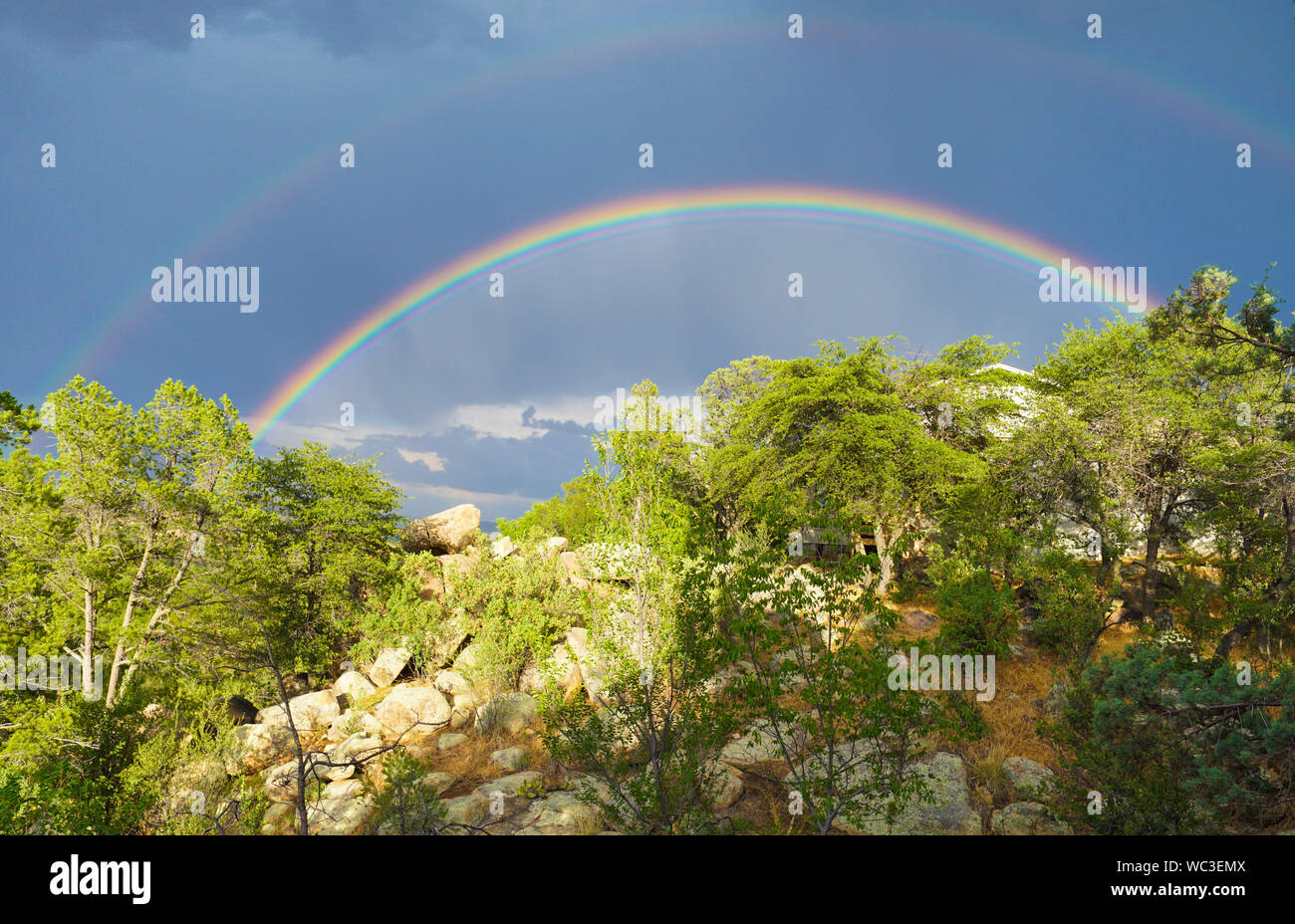 A Double rainbow shines brightly over the high desert landscape. Stock Photo