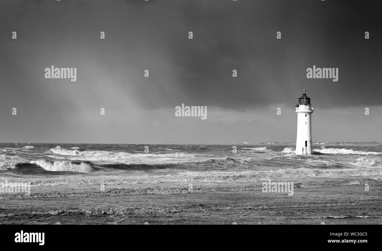 Rainstorm approaching lighthouse in monochrome Stock Photo