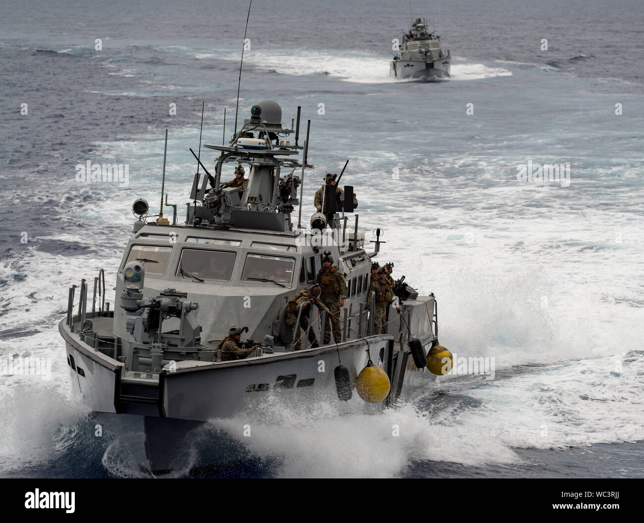 190826-N-LN093-1110  SANTA RITA, Guam (Aug. 26, 2019) Mark VI patrol boats attached to Coastal Riverine Squadron (CRS) 2 with embarked Marines assigned to 3rd Reconnaissance Battalion, 3rd Marine Division and Clearance Divers assigned to the Royal Canadian Navy’s Fleet Diving Pacific and Atlantic Units, navigate near Apra Harbor, during a visit, board, search and seizure (VBSS) subject matter expert knowledge exchange as part of Exercise HYDRACRAB. HYDRACRAB is a quadrilateral exercise conducted by forces from Australia, Canada, New Zealand, and U.S. Naval forces. The purpose of this exercise Stock Photo