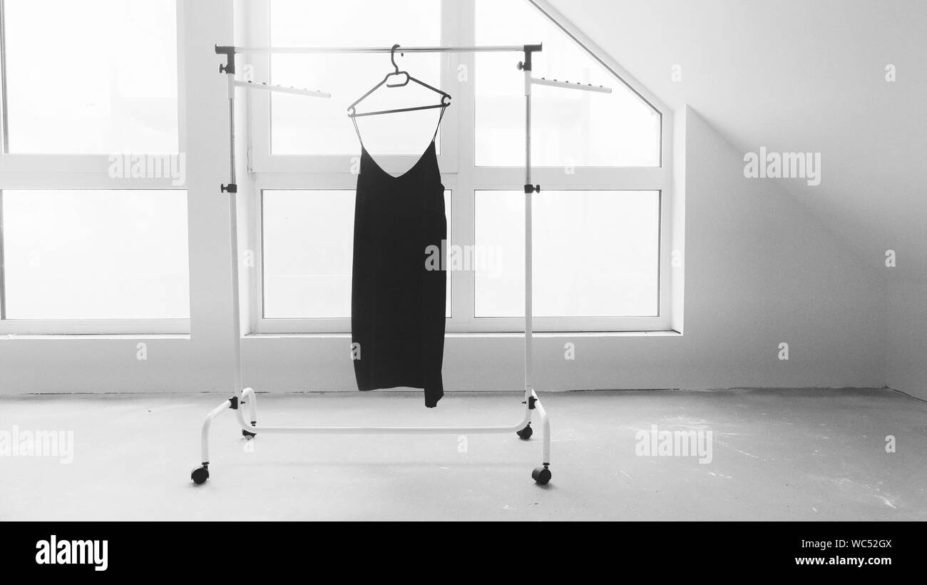 Black Dress On Hanger Against The Window Stock Photo