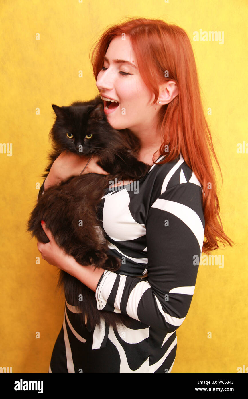 Happy Cheerful Lady With Orange Hair Holds Pretty Cat On Arms And