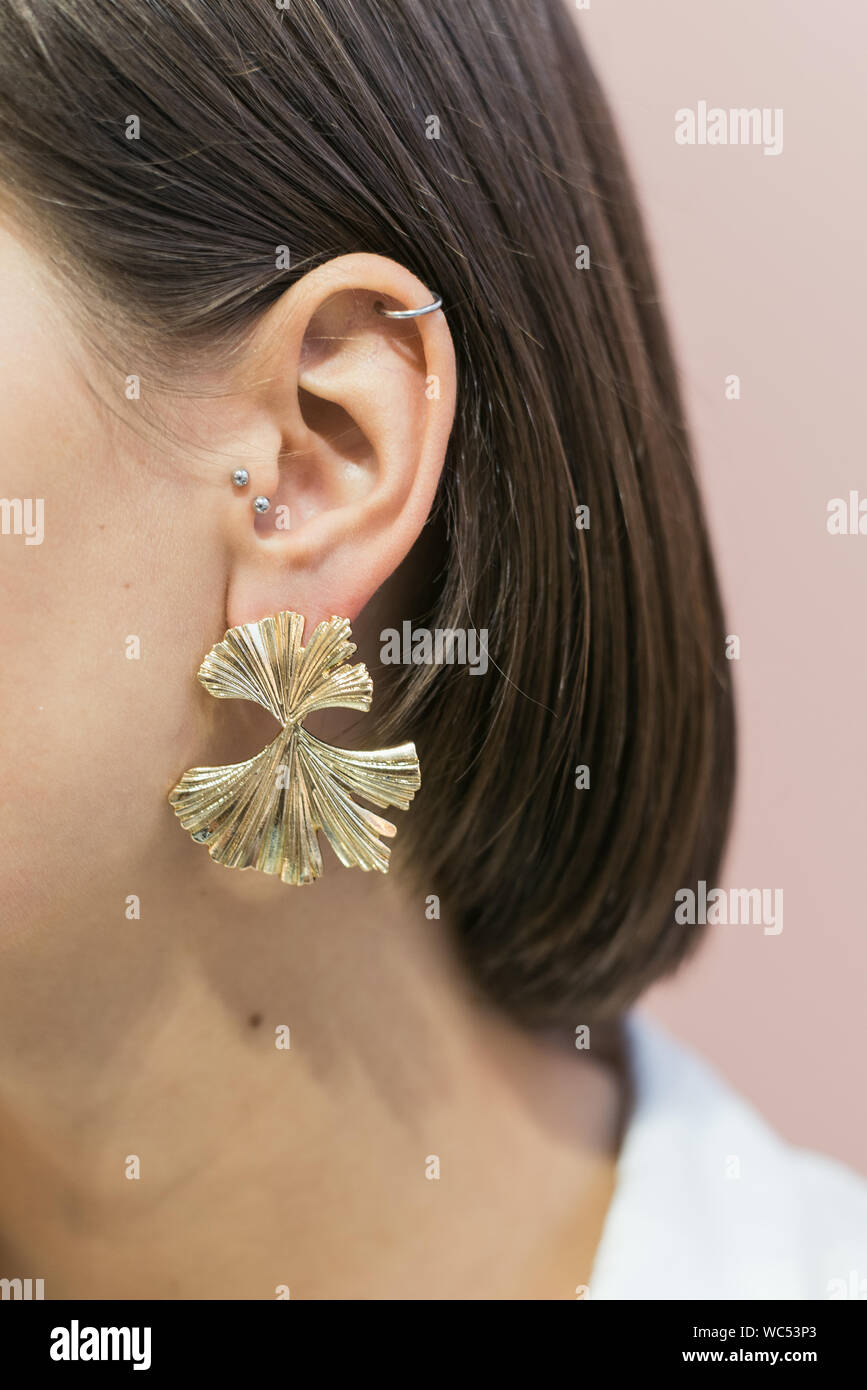 trendy stylish round gold earrings on the girl s ear with bob haircut