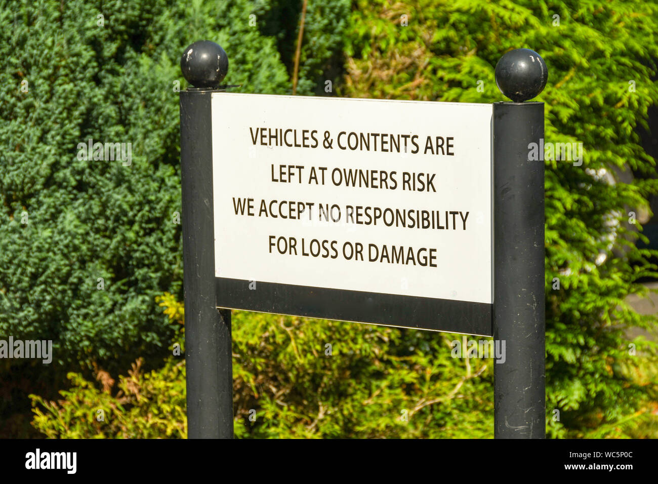 Notice warning drivers that the premises takes no responsibility for theft or loss from parked vehicles Stock Photo