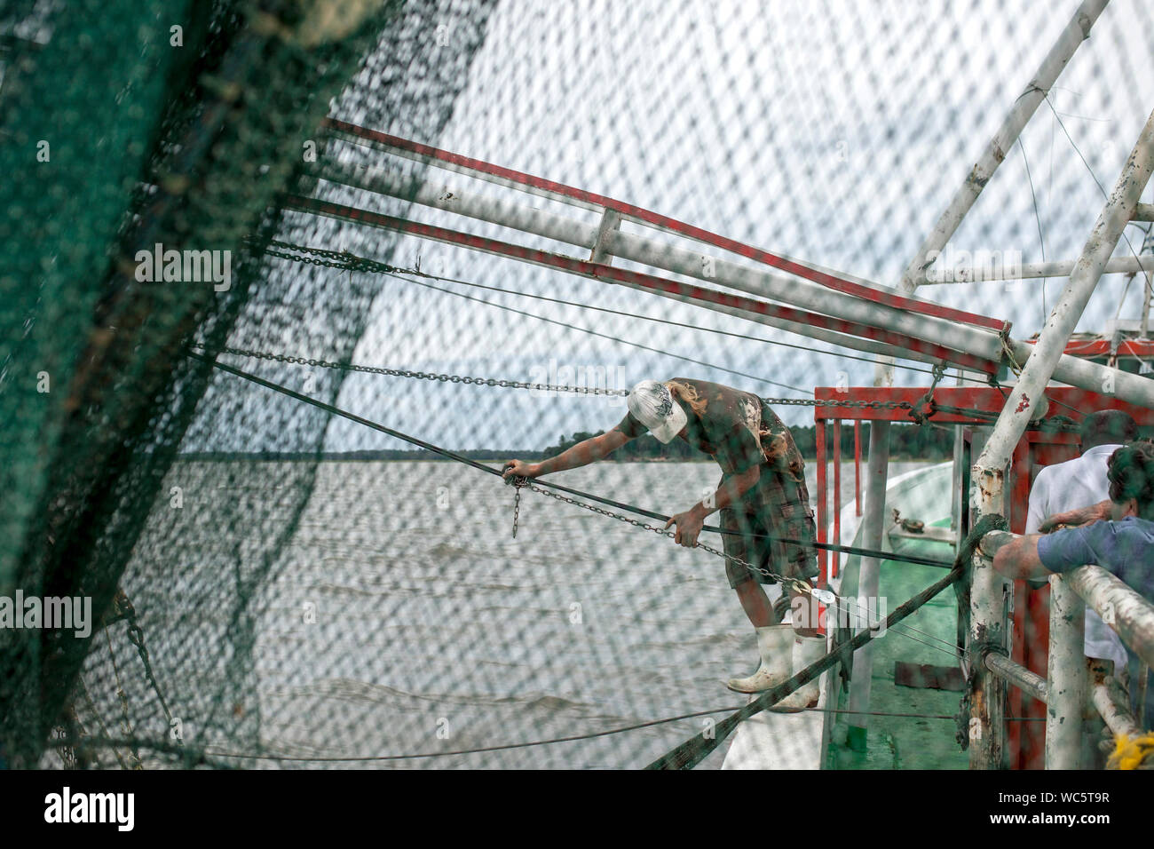 Commercial fishermen working on shrimping boat in South Carolina, view