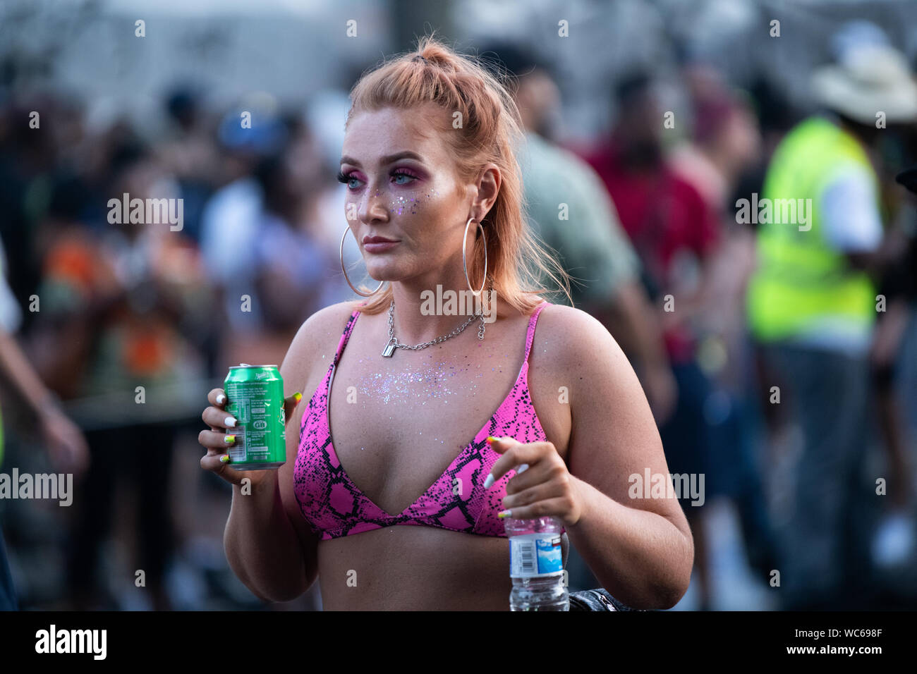 a white woman wearing a hot pink bra holding a can of sprite at