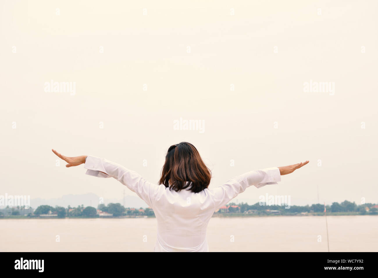 Rear View Of Woman With Arms Outstretched Stock Photo