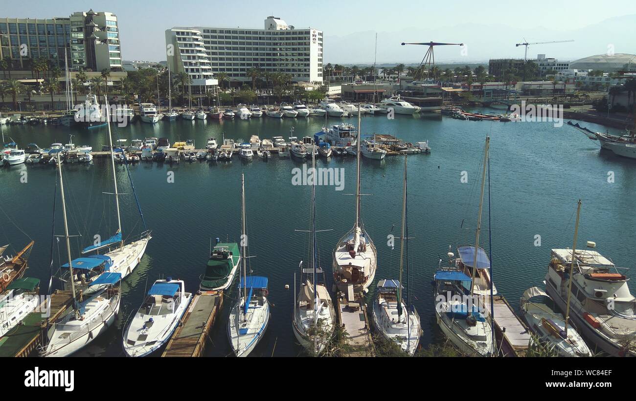 Boats Moored At Harbor In City Against Sky Stock Photo