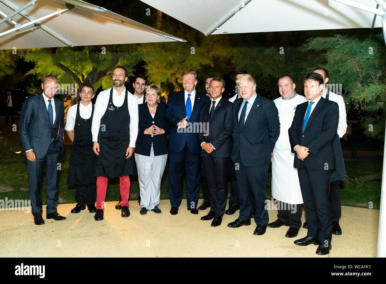World leaders pose for a photo with the chef and staff following the G7 Leaders’ Dinner at the Biarritz Lighthouse August 24, 2019 in Biarritz, France. Standing from left to right are: European Council President Donald Tusk, restaurant staff, German Chancellor Angela Merkel, U.S. President Donald Trump, French Prime Minister Emmanuel Macron, British Prime Minister Boris Johnson and Italian Prime Minister Giuseppe Conte. Stock Photo