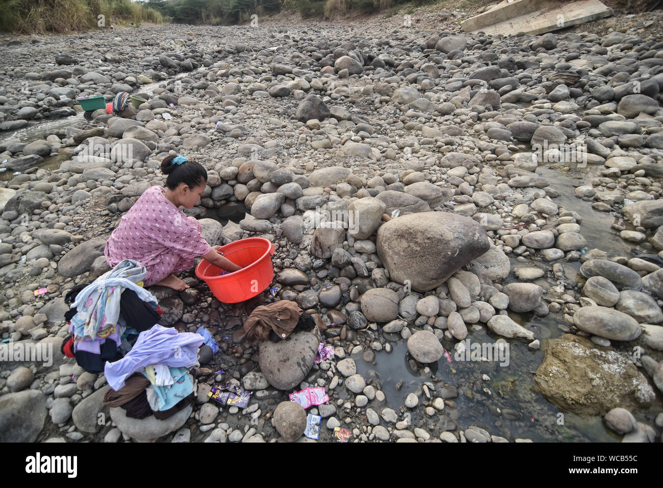 Bekasi, Indonesia. 27th Aug, 2019. A resident seen washing from a dry  Cipamingkis river for domestic use as their wells dry out due to drought in  the summer season.The Meteorology, Climatology and