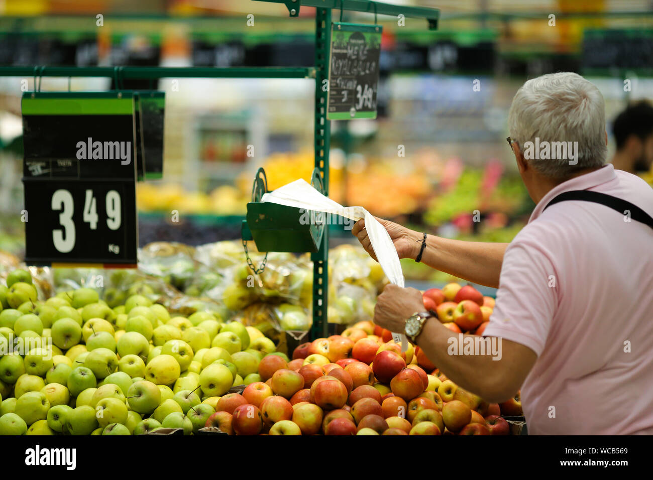 A man uses biodegradable plastic food bags to buy fruits and vegetables from the supermarket Stock Photo