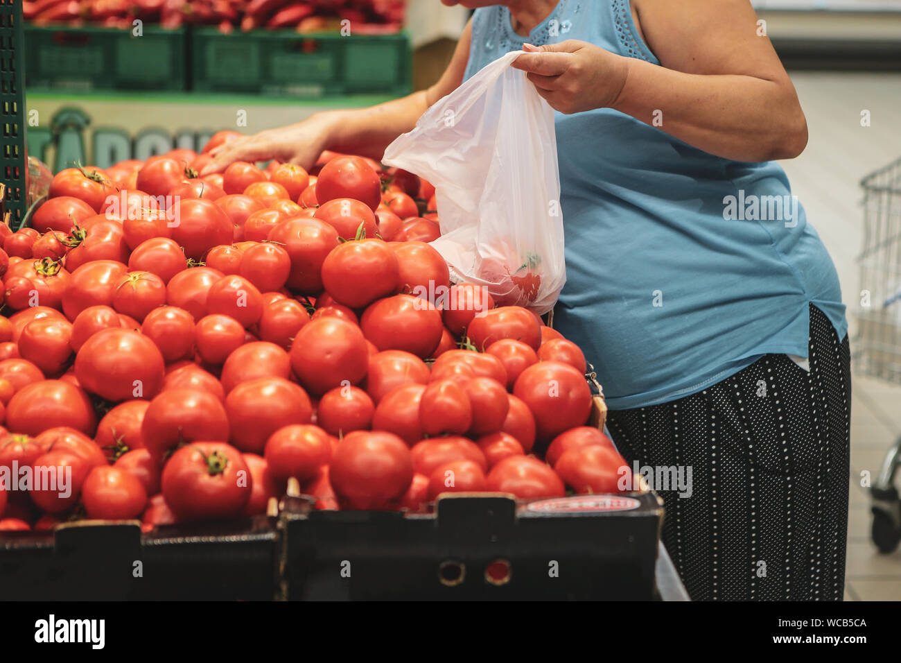 A woman uses biodegradable plastic food bags to buy fruits and vegetables from the supermarket Stock Photo