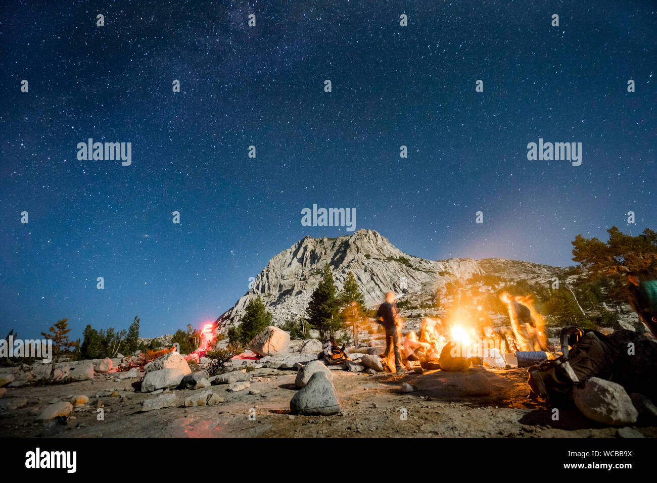 People Camping On Field Against Star Field Stock Photo