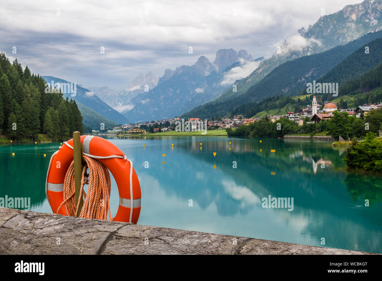Life Belt Hanging By Lake By Mountains Against Sky Stock Photo