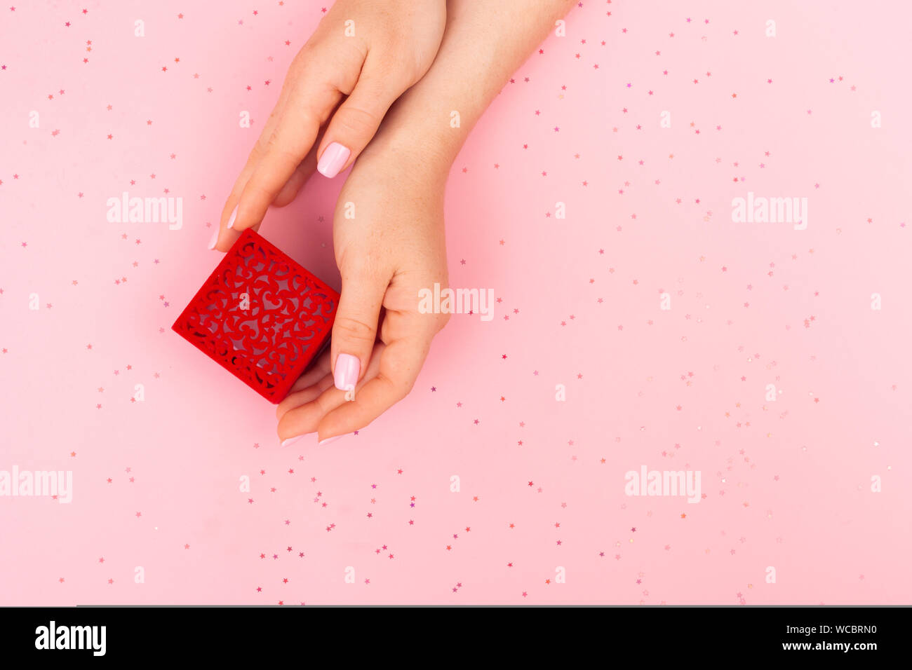 The Girl Takes A Red Patterned Box With A Ring With Two