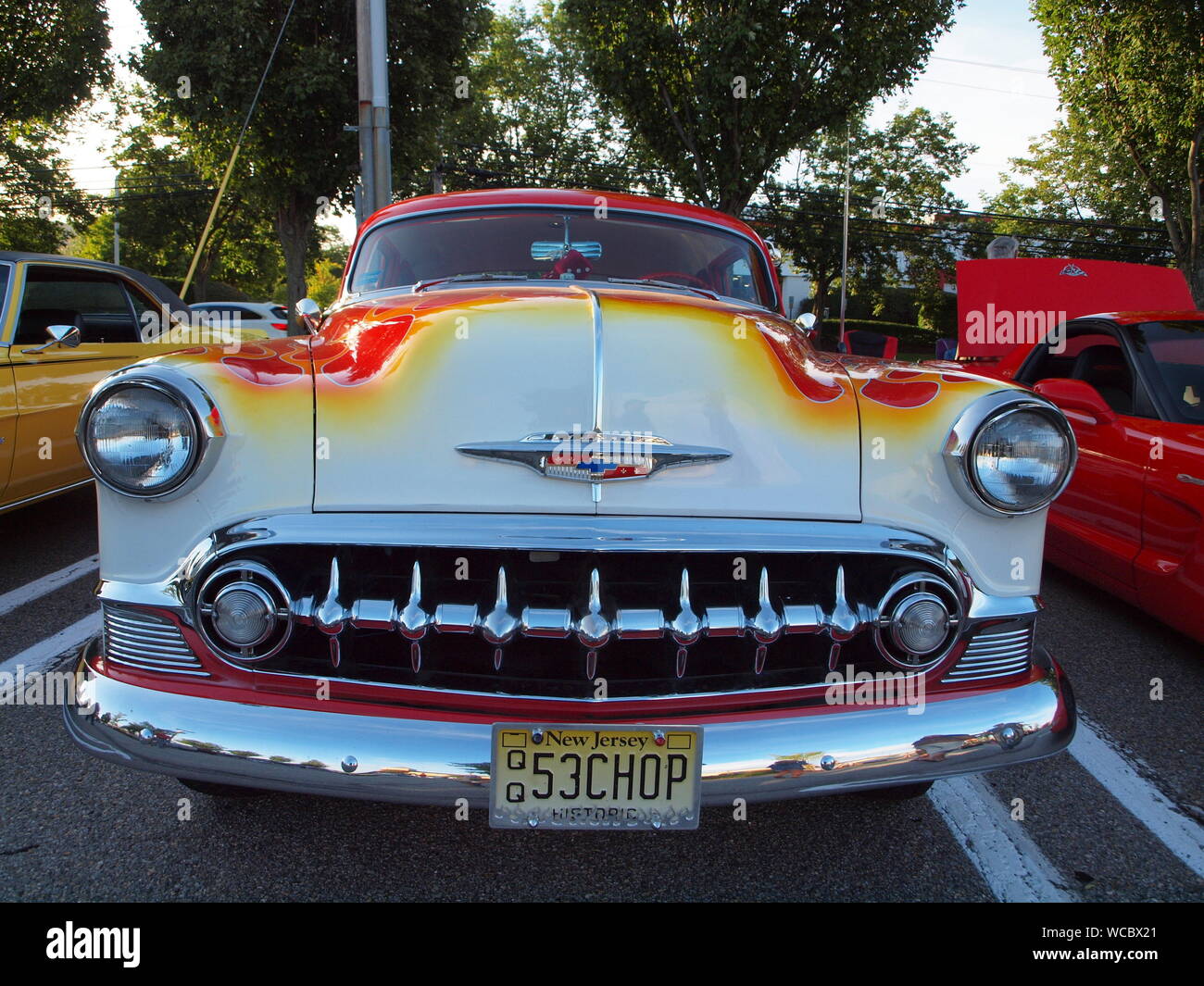 Customized 1953 Chevy BelAir at a local car show with heavy chrome and flamed paint in reds and oranges on a white hood. Stock Photo